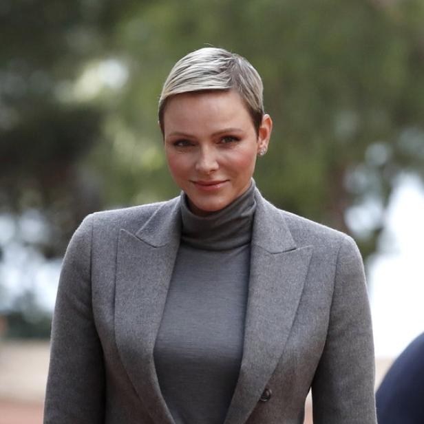 Fürstin Charlène von Monaco trägt einen grauen Blazer und einen Rollkragenpullover.