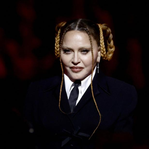 Madonna in einem schwarzen Anzug mit geflochtenen Zöpfen.