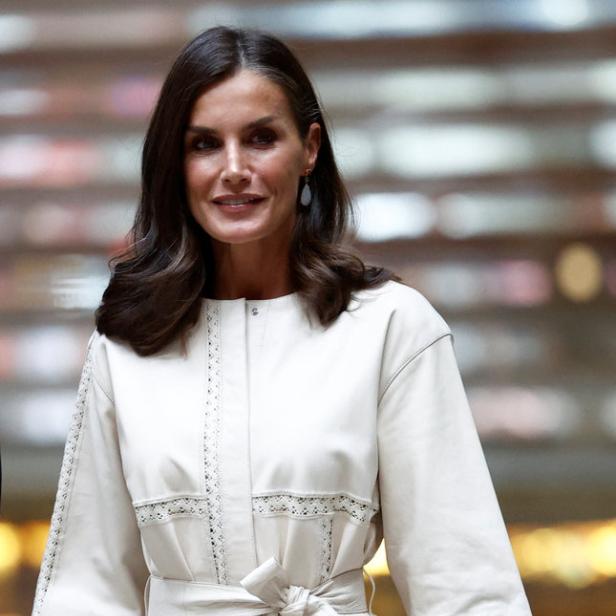 Königin Letizia trägt ein weißes Kleid und eine rote Handtasche.