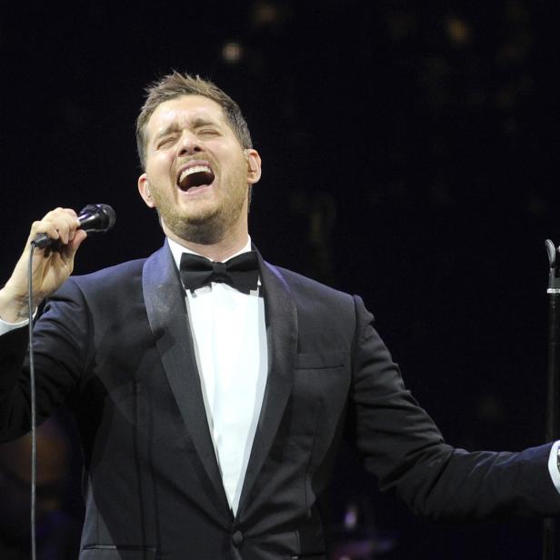 Michael Bublé singt mit weit geöffnetem Mund in einem schwarzen Smoking.