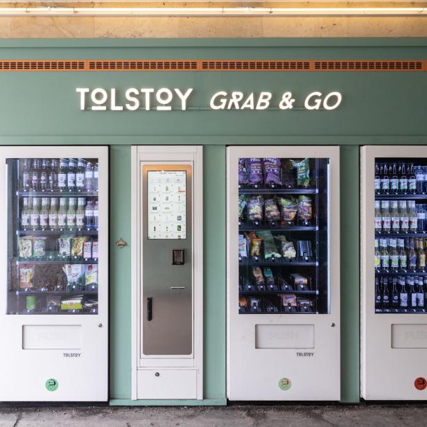 Mehrere „Tolstoy Grab & Go“-Verkaufsautomaten mit Getränken und Snacks.