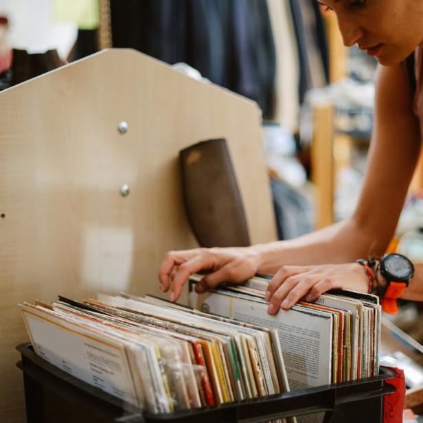 Eine Frau durchsucht eine Kiste mit Schallplatten.