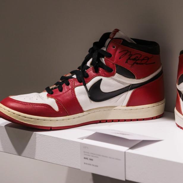 Zwei signierte Michael Jordan „Chicago“ Nike Air Jordan 1 High Sneaker von 1985 stehen auf einem Regal.
