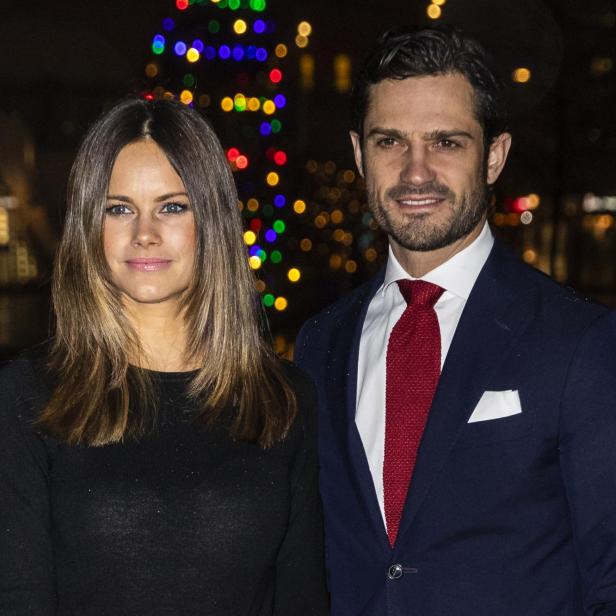 Prinz Carl Philip und Prinzessin Sofia von Schweden posieren vor einem Weihnachtsbaum.
