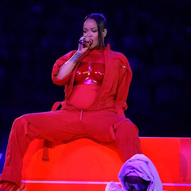 Rihanna tritt in einem roten Overall während der Halbzeitshow des Super Bowl auf.