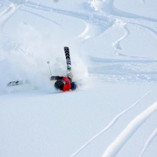 Ein Skifahrer stürzt im Schnee. 