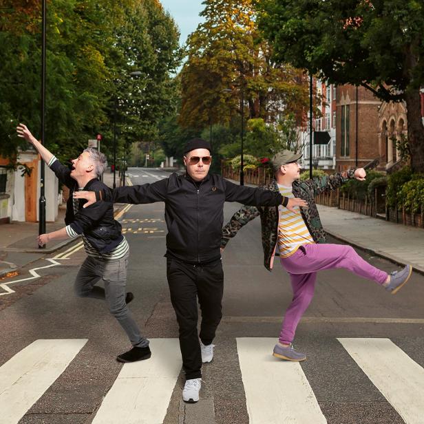 Drei Männer überqueren einen Zebrastreifen und ahmen das Cover von „Abbey Road“ nach.