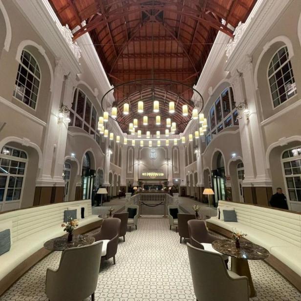 Innenansicht eines eleganten Loungebereichs mit hohen Decken und Kronleuchter.