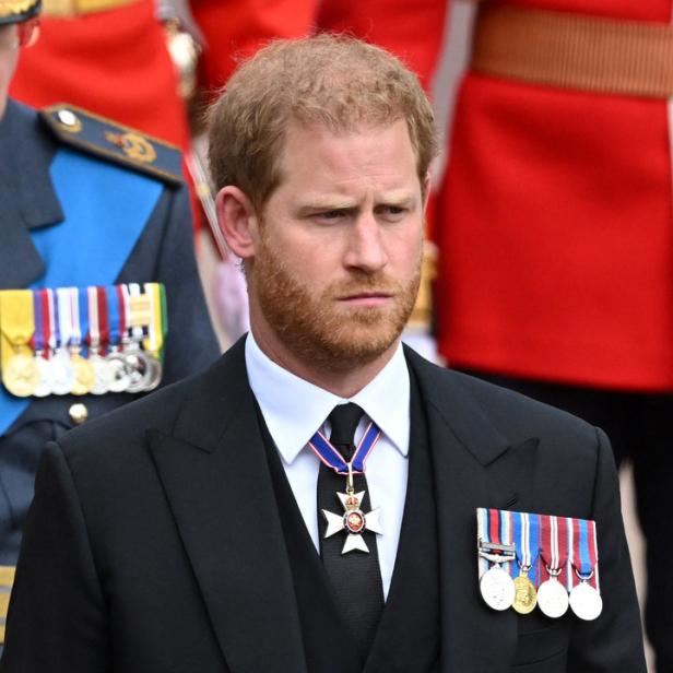Prinz Harry in einem dunklen Anzug mit Orden und Ehrenzeichen.