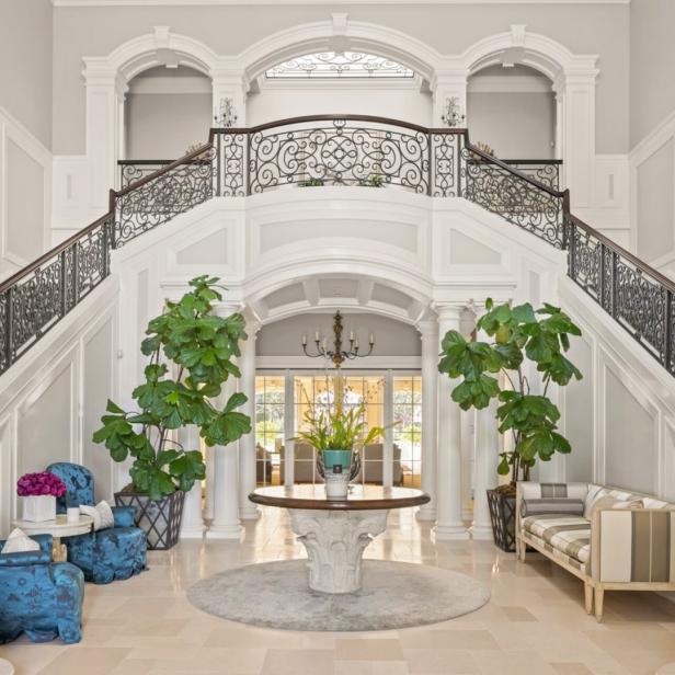 Eine elegante Eingangshalle mit einer geschwungenen Treppe und dekorativen Elementen.