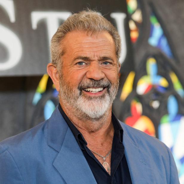 Mel Gibson lächelt in einem blauen Sakko.