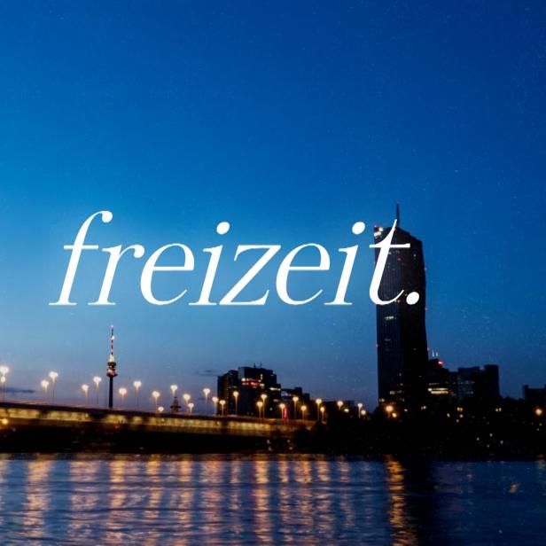 Die Skyline von Wien bei Nacht mit dem Schriftzug „freizeit.“ im Vordergrund.
