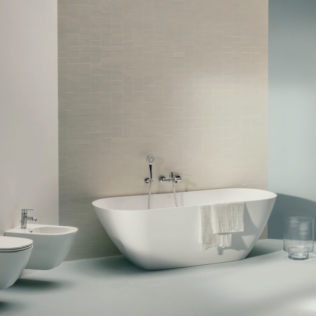 Ein modernes Badezimmer mit freistehender Badewanne, Waschtisch und Toilette.