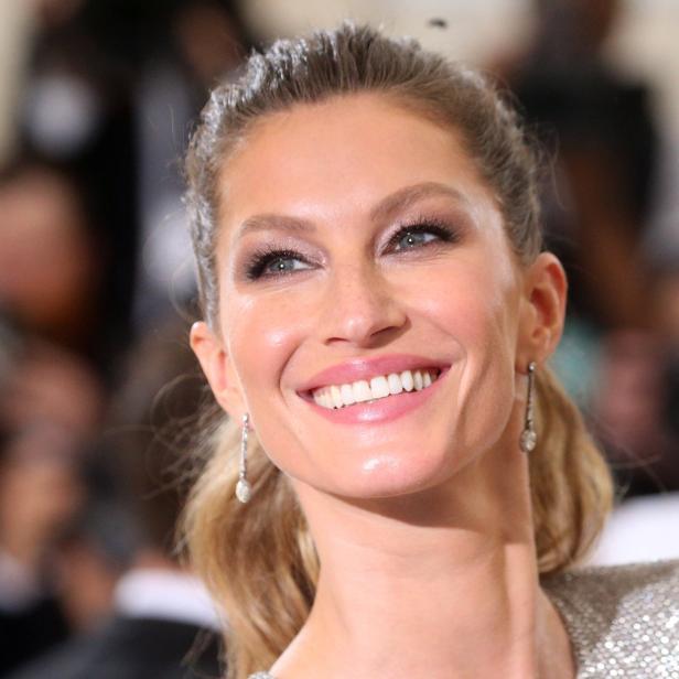 Gisele Bündchen lächelt und blickt nach oben.