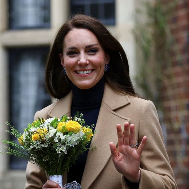 Prinzessin Kate hält einen Blumenstrauß und winkt.