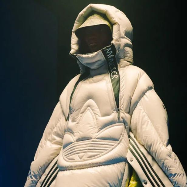 Eine Person trägt eine übergroße, weiße Daunenjacke von Moncler x Adidas.