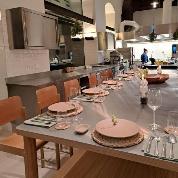 Ein langer Tisch ist für ein Abendessen in einem Restaurant gedeckt.