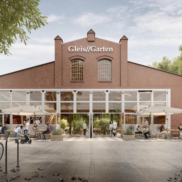 Das Restaurant „Gleis//Garten“ mit Gästen im Außenbereich an einem sonnigen Tag.