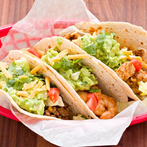 Mehrere Street Tacos mit verschiedenen Füllungen in einem roten Korb.