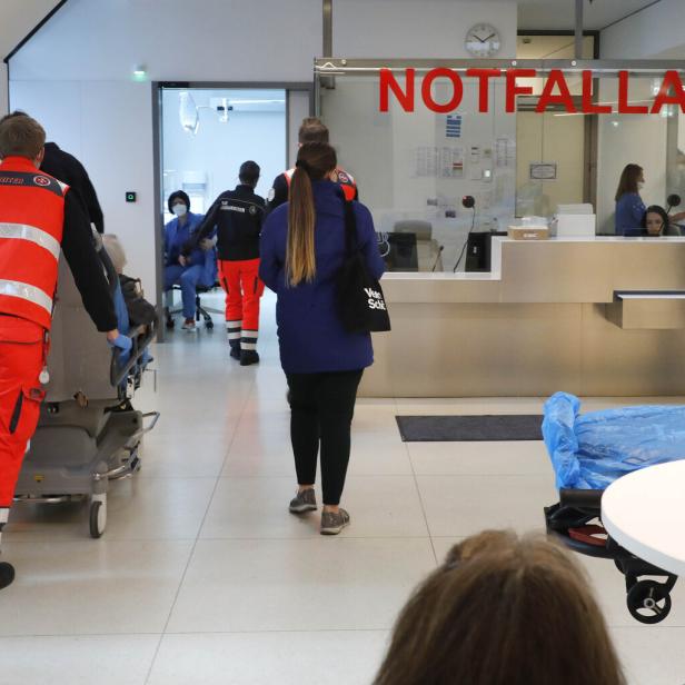In einem Krankenhaus bringen Sanitäter einen Patienten in die Notaufnahme.