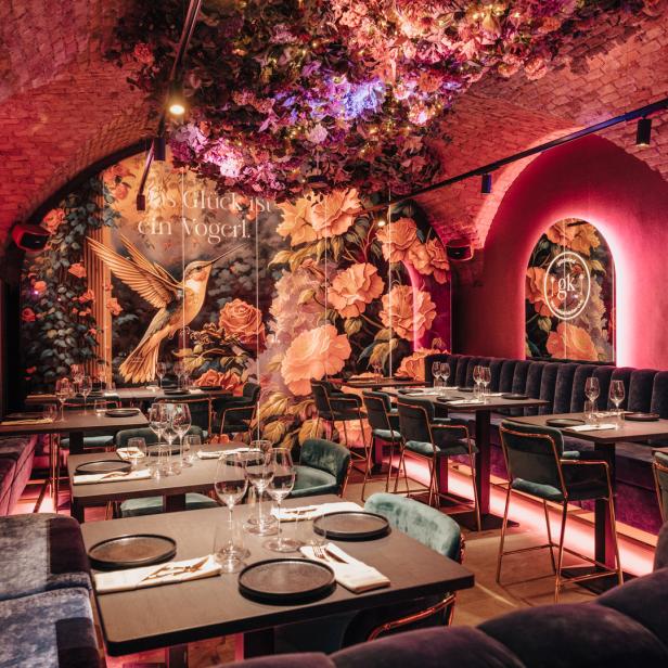 Ein elegant eingerichtetes Restaurant mit floralen Wandmalereien und gedämpfter Beleuchtung.