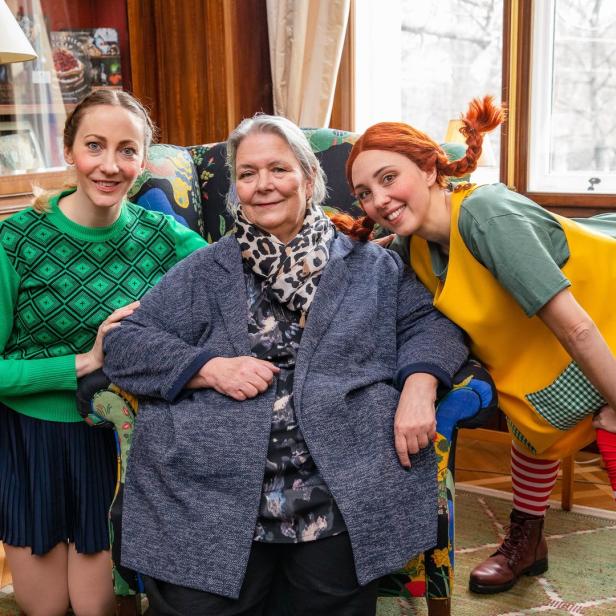 Eine Frau, verkleidet als Pippi Langstrumpf, posiert mit zwei anderen Frauen für ein Foto.
