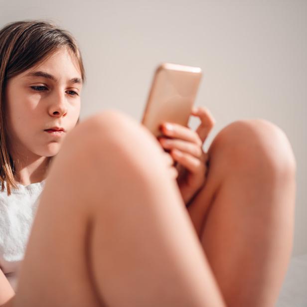 Ein Mädchen schaut ins Smartphone.