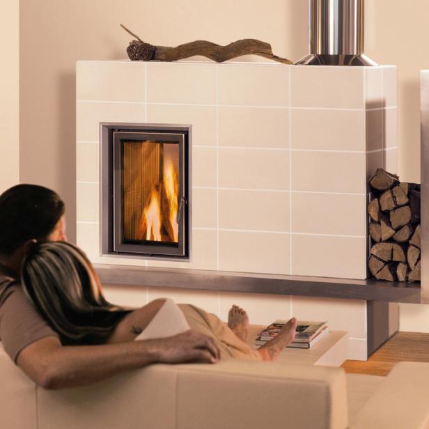 Ein Paar entspannt sich vor einem Kamin mit brennendem Feuer.