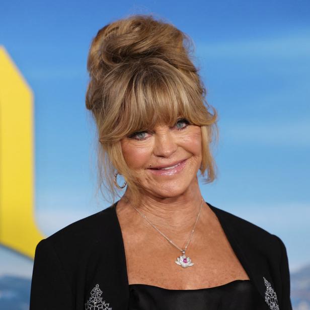 Goldie Hawn posiert vor einem hellblauen Hintergrund.