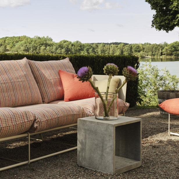 Ein Sofa und ein Sessel stehen im Freien mit Blick auf einen See.