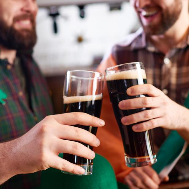 Zwei Männer stoßen mit irischem Stout auf den St. Patrick's Day an.