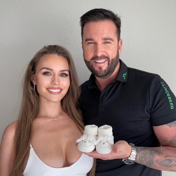 Michael und Laura Wendler halten Babyschuhe in der Hand.