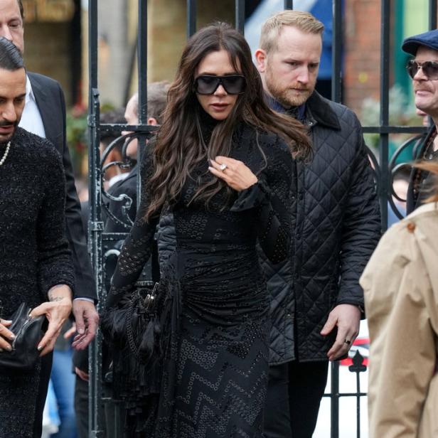 Victoria Beckham trägt ein schwarzes Kleid und eine Sonnenbrille.