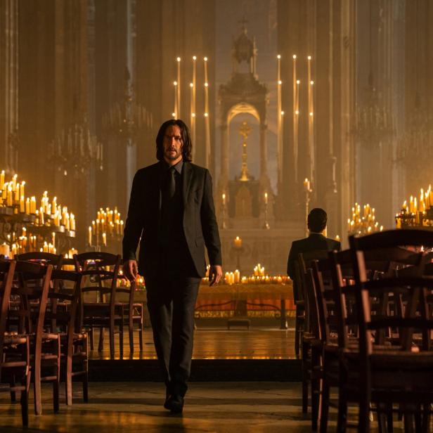 John Wick geht durch eine mit Kerzen beleuchtete Kirche.
