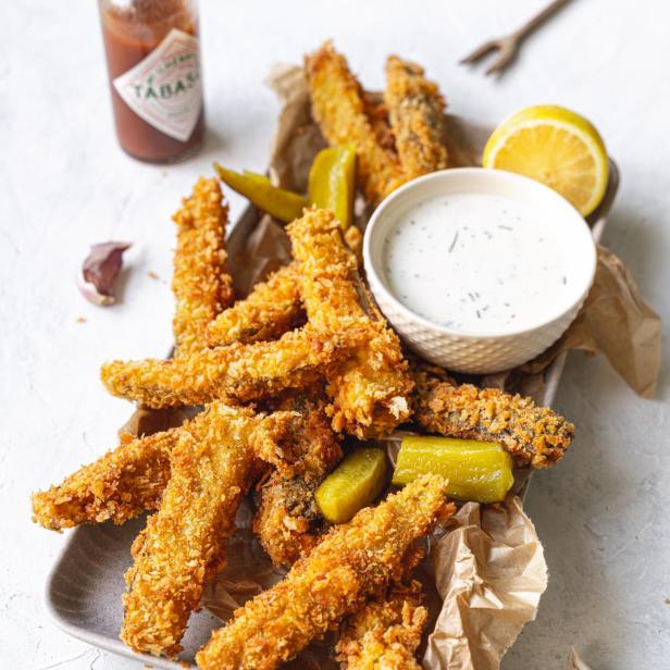 Frittierte Essiggurken werden mit Ranch-Dressing, Zitrone und Tabasco serviert.