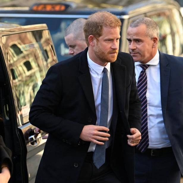 Prinz Harry steigt aus einem Auto, begleitet von Sicherheitsleuten.