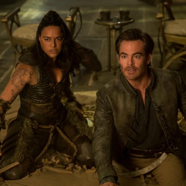 Michelle Rodriguez und Chris Pine in Kostümen knien auf dem Boden.