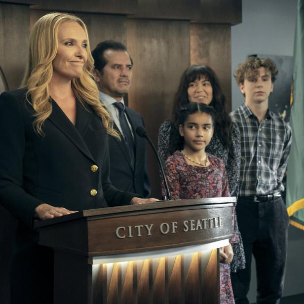 Eine Frau steht an einem Rednerpult mit der Aufschrift „City of Seattle“, umgeben von vier weiteren Personen.