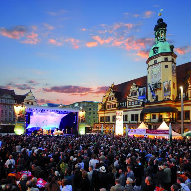 Eine große Menschenmenge versammelt sich vor einer Bühne auf dem Marktplatz in Leipzig.