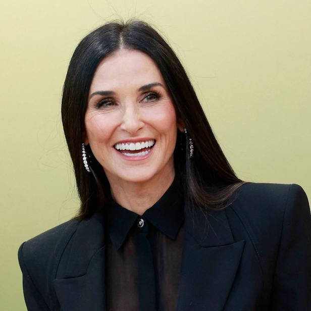 Demi Moore lächelt in einem schwarzen Blazer.