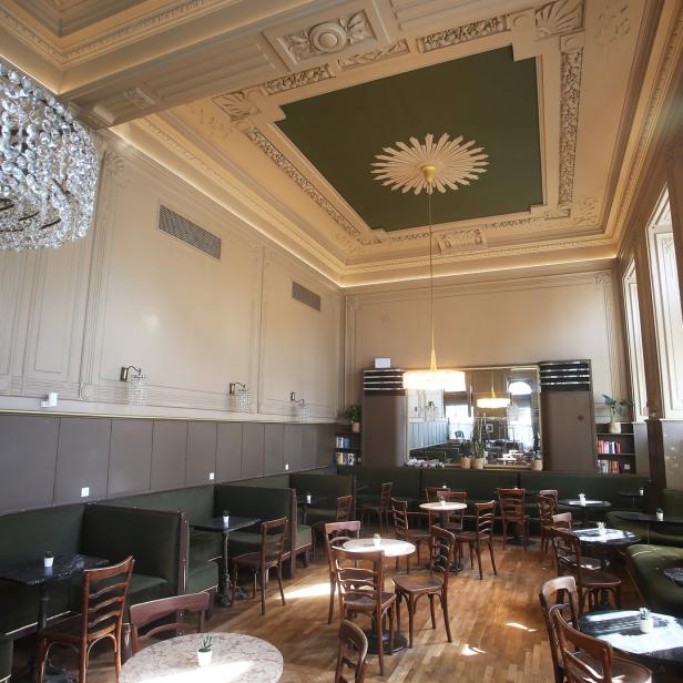 Ein elegantes Café mit Sitzgruppen und einem großen Kristalllüster.