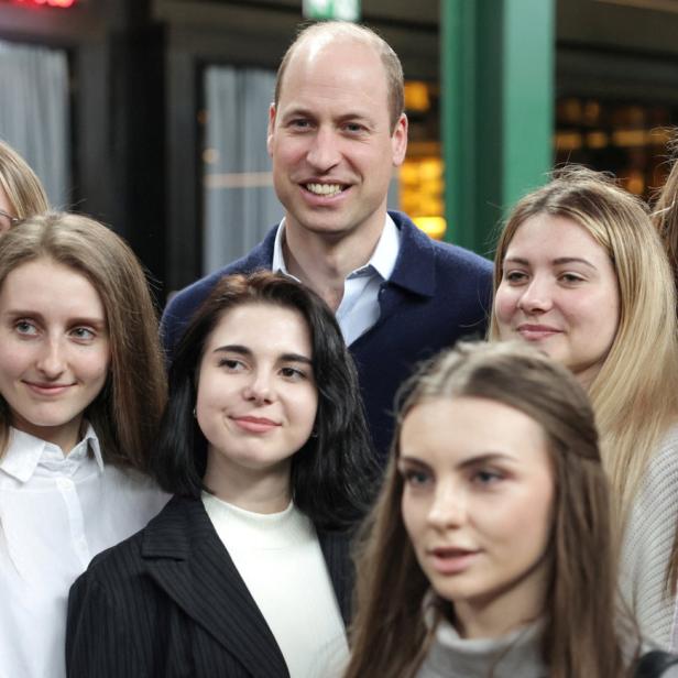 Prinz William posiert mit einer Gruppe junger Frauen.