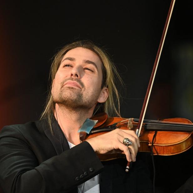 Ein Mann mit langen blonden Haaren spielt Violine.