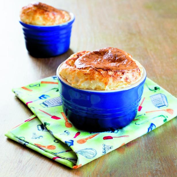 Zwei Soufflés in blauen Förmchen auf einem Küchentuch.