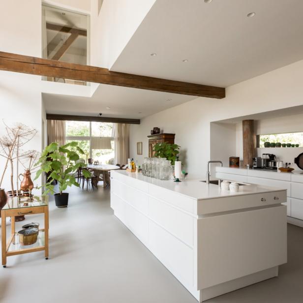 Helle, moderne Küche mit Kochinsel und Holzbalken.
