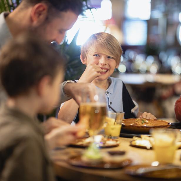 Eine Familie sitzt beim Tisch und isst.