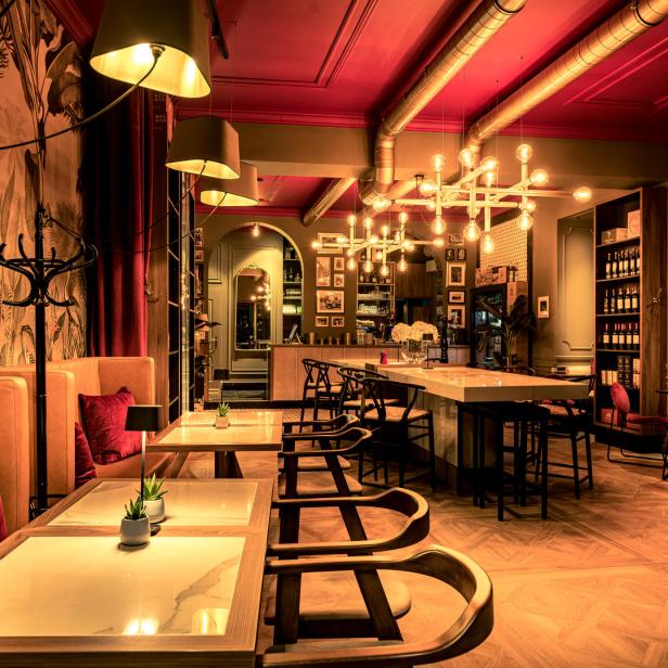 Ein elegant eingerichtetes Restaurant mit Tischen, Stühlen und einer Bar.