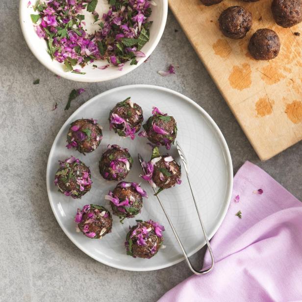 Fleischbällchen werden mit einer Mischung aus Kräutern und Rotkohl garniert.