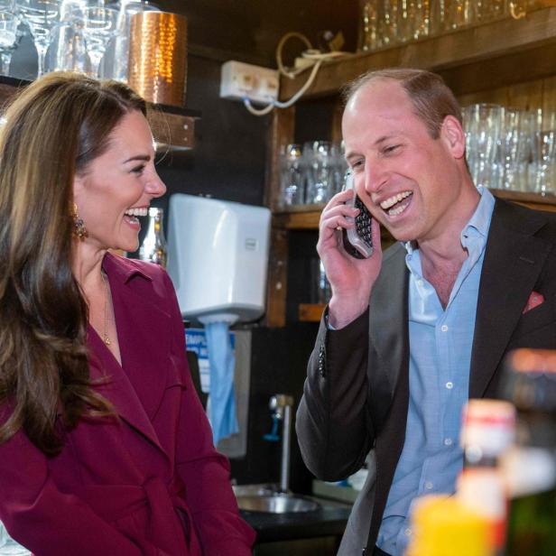Prinzessin Kate und Prinz William lachen, während er telefoniert.