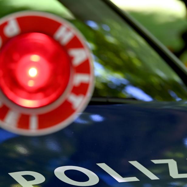 Polizeiauto hinter Kelle mit Aufschrift "Halt Polizei"